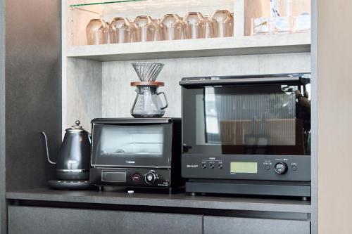 a microwave and a television on a shelf at IoTele南青山 in Tokyo