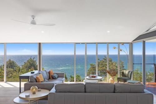 ein Wohnzimmer mit Couch und Blick aufs Meer in der Unterkunft Sandcastle by Coast Hosting in Wamberal