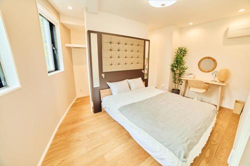 a bedroom with a large bed and a mirror at IoTele南青山 in Tokyo