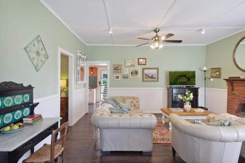 a living room with two couches and a table at Cosy Family Farm Stay - Daily Animal Feeding in Wamberal