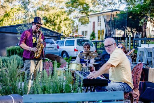 a group of people playing music in a yard at Cosy Family Farm Stay - Daily Animal Feeding in Wamberal