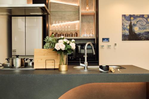 a kitchen with a counter with a vase of flowers at IoTele南青山 in Tokyo