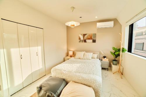 a bedroom with a bed and a large window at IoTele南青山 in Tokyo
