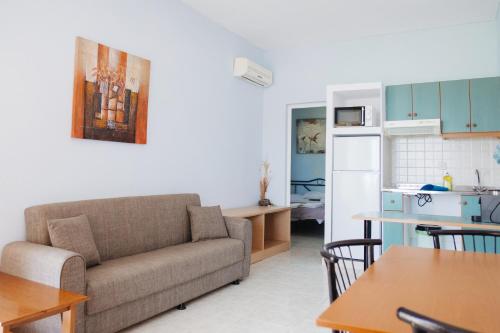 a living room with a couch and a kitchen at Finikas Apartments in Plakias