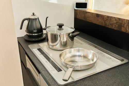 a tray with two pans and a pot on a kitchen counter at IoTele南青山 in Tokyo