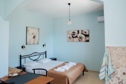 a bedroom with two beds and a table in a room at Finikas Apartments in Plakias