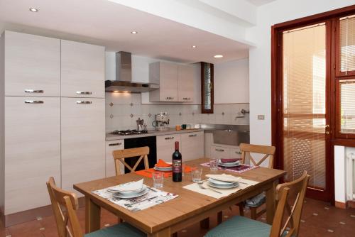 a kitchen with a wooden table with a bottle of wine at Casa Corinna in Ponsacco