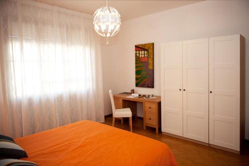 a bedroom with a bed and a desk and a chandelier at Casa Corinna in Ponsacco