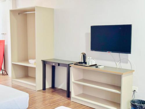 a living room with a desk with a tv on it at Zaque's Hotel in Sungai Petani