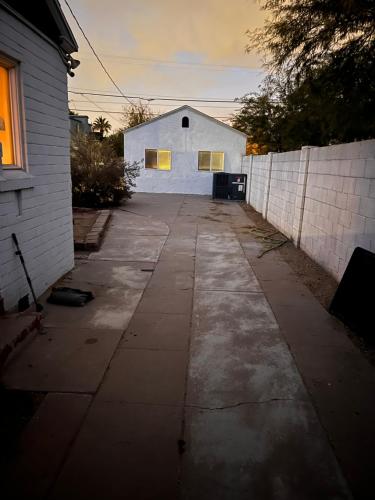 an empty driveway with a white building in the background at Downtown Private Guesthouse in Phoenix