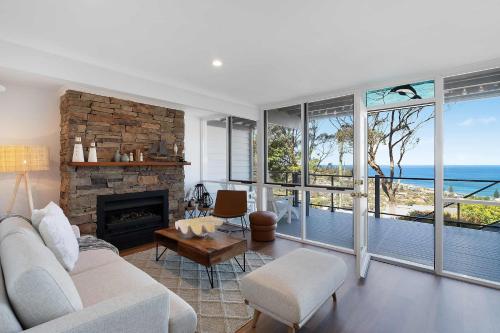 Una sala de estar con un sofá y una chimenea. en The Glass House by Coast Hosting, en Copacabana