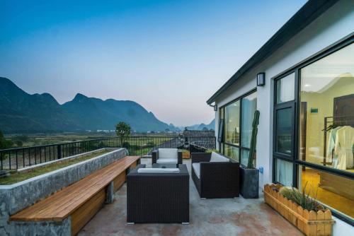a balcony with furniture and a view of mountains at Gui zhou Wan Feng Lin Eave Boutique Hotel in Nahui