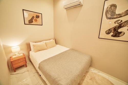 a small bedroom with a bed and a night stand at IoTele南青山 in Tokyo
