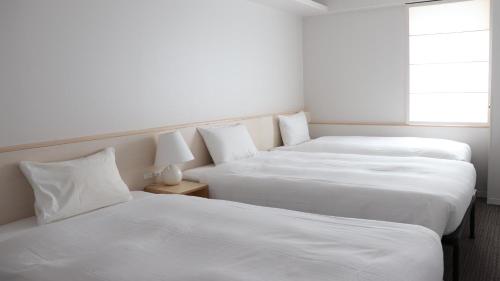 two beds sitting next to each other in a room at Shin-Osaka Station Hotel in Osaka