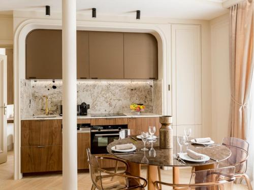une cuisine avec une table et des chaises dans une pièce dans l'établissement Merveil - Signature Suite - Marais -Turbigo III, à Paris