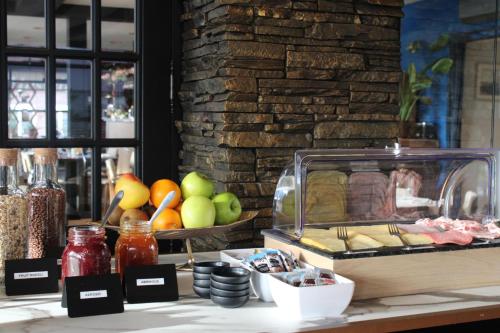 a counter with a buffet of food and fruits at Hotel Philippe Suites I Kloeg Collection in Philippine