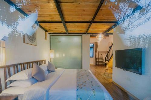 a bedroom with a large bed and a tv at Gui zhou Wan Feng Lin Eave Boutique Hotel in Nahui