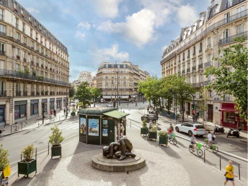une rue de la ville avec une statue au milieu dans l'établissement Merveil - Signature Suite - Marais -Turbigo III, à Paris