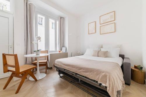 une chambre avec un lit, une table et une chaise dans l'établissement Cozy studio in Montmartre, à Paris
