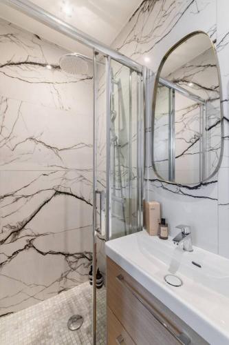 une salle de bain avec un lavabo et un miroir dans l'établissement Cozy studio in Montmartre, à Paris