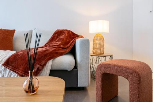 - un salon avec un canapé et un vase sur une table dans l'établissement Le Bertrand - Cosy - 7 pers- Invalides-Tour Eiffel, à Paris