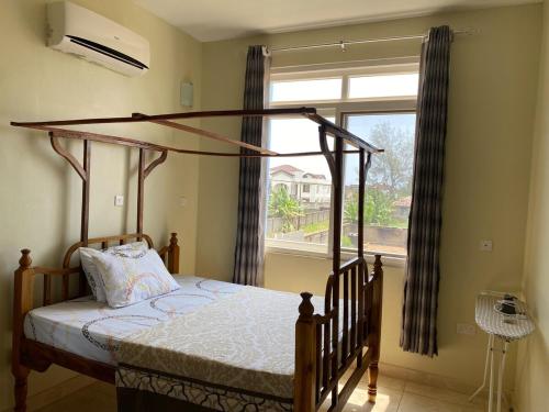 a bedroom with a canopy bed in front of a window at Zanzibar Manolo A class in Zanzibar City