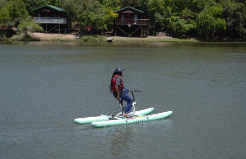 a man standing on a paddle board in the water at ATKV Klein-Kariba in Bela-Bela
