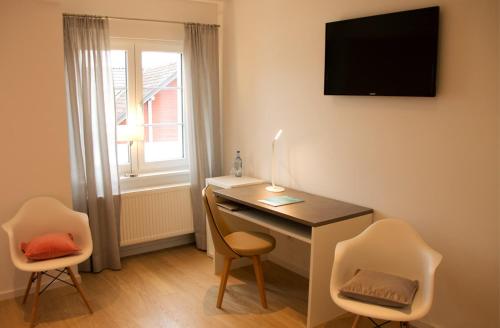 a room with a desk and two chairs and a window at Landhotel Adler in Sigmarszell