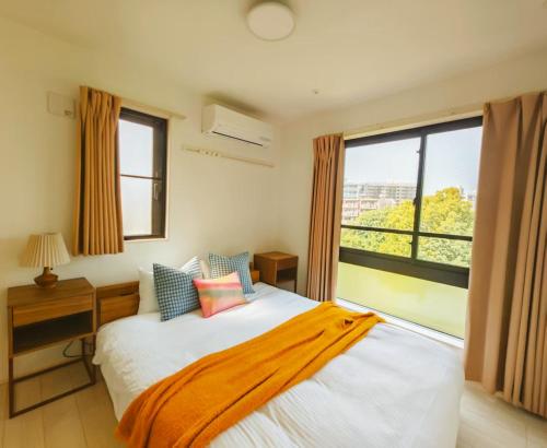 a bedroom with a bed and a large window at Mi-HOTEL ATELIER SHINJUKU in Tokyo