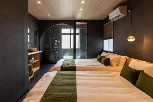 a large bedroom with two beds and a bathroom at JAPAVISTA Noble in Osaka
