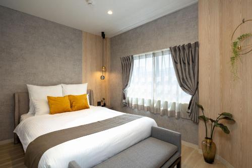 a bedroom with a large bed and a window at JAPAVISTA Noble in Osaka
