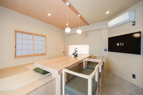 a dining room with a wooden table and chairs at JAPAVISTA Noble in Osaka