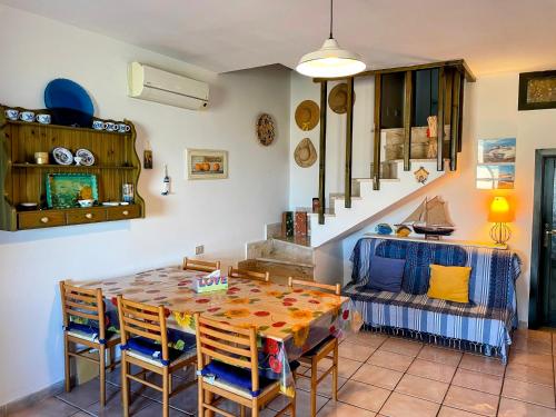 ein Esszimmer mit Tisch und Stühlen und einer Couch in der Unterkunft Casa Margot Costa Verde Sardinia in Torre Dei Corsari