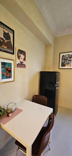 a white table and chairs in a room with a refrigerator at Sadama Holiday Apartment in Kõrgessaare