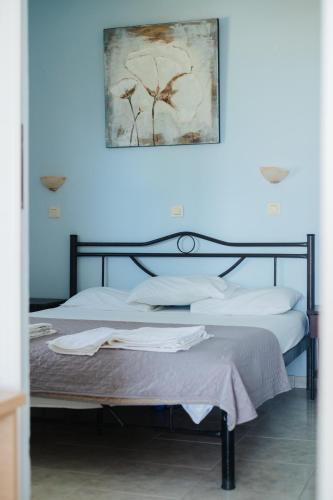 a bedroom with two beds and a blue wall at Finikas Apartments in Plakias