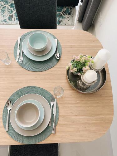 a table with plates and utensils on it at Lilly Lagoon Townhouse in Ţāqah