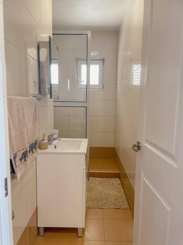 a white bathroom with a sink and a shower at Prizba Tomas in Blato
