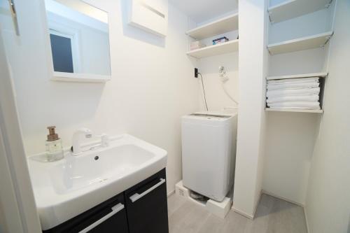 a white bathroom with a sink and a toilet at Mi-HOTEL ATELIER SHINJUKU in Tokyo