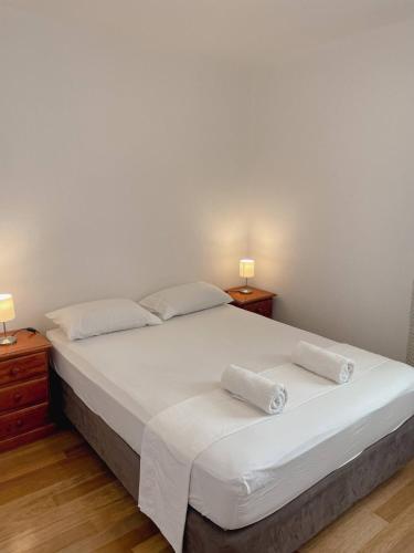 a bedroom with a white bed with two night stands at Prizba Tomas in Blato