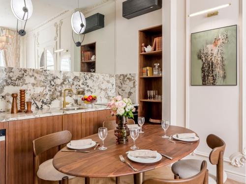 une salle à manger avec une table et des chaises en bois dans l'établissement Merveil - Signature Suite-Champs Elysees- Marignan, à Paris
