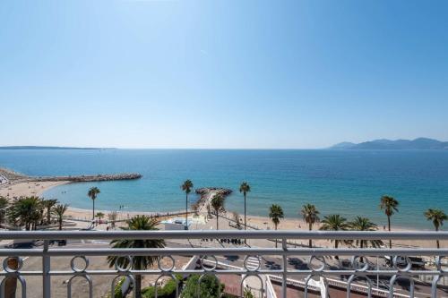 une vue sur une plage avec des palmiers et l'océan dans l'établissement Cannes Sea View & Beach Access, à Cannes
