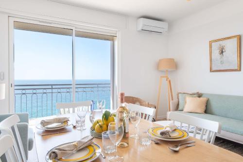 une salle à manger avec une table avec vue sur l'océan dans l'établissement Cannes Sea View & Beach Access, à Cannes