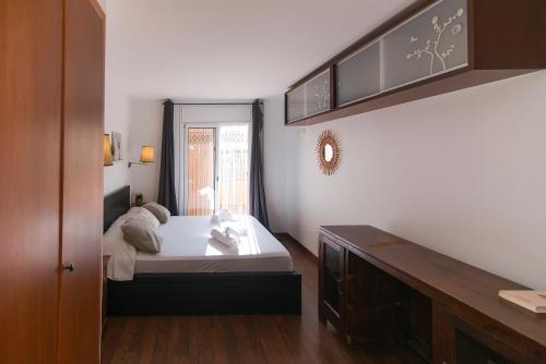 a small bedroom with a bed and a window at WELCS APARTAMENTO 200 PDA CON TERRAZA y PISCINA in Palafrugell