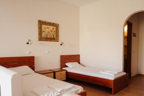 a room with two beds and a picture on the wall at Finikas Apartments in Plakias