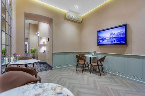 a waiting room with tables and a tv on the wall at Nizami Central Park Hotel in Baku