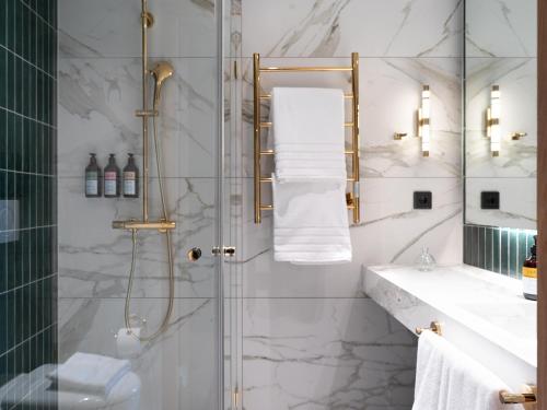 a bathroom with a shower with a sink and a mirror at Elite Hotel Frost - Hotel & Spa in Kiruna