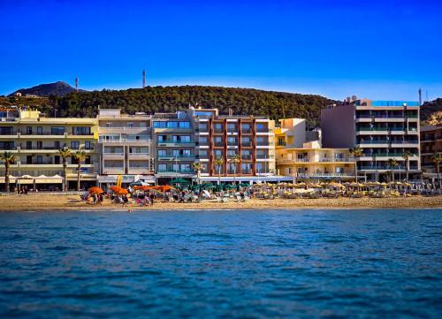a group of buildings on a beach next to the water at Theo Beach Hotel Apartments in Rethymno Town