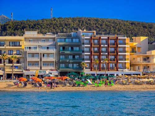 a beach with umbrellas and people on the beach at Theo Beach Hotel Apartments in Rethymno Town