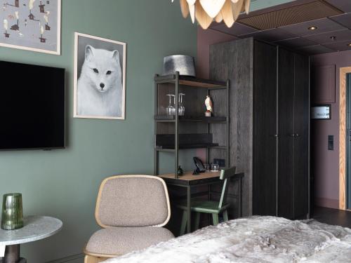a bedroom with a desk and two chairs and a tv at Elite Hotel Frost - Hotel & Spa in Kiruna