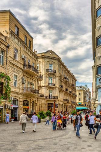 a group of people walking down a city street at Nizami Central Park Hotel in Baku
